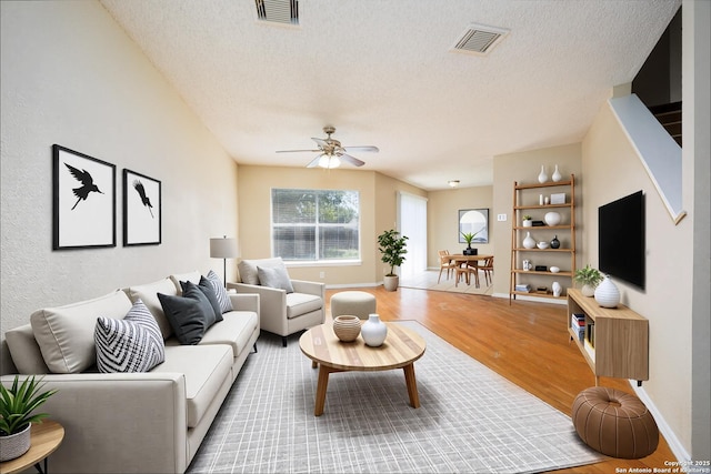 3702 Candlebluff, San Antonio, TX 78244 - living area featuring a textured ceiling, light wood-style floors, a ceiling fan, and baseboards