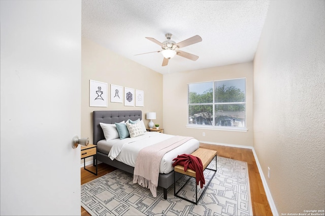 3702 Candlebluff, San Antonio, TX 78244 - bedroom with light wood finished floors, baseboards, ceiling fan, and a textured ceiling