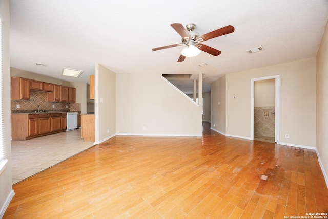 3702 Candlebluff, San Antonio, TX 78244 - unfurnished living room featuring a sink, a ceiling fan, light wood finished floors, baseboards, and stairs