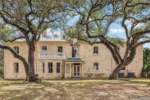 7735 Mocking Bird Ln, San Antonio, TX 78229 - back of property with a balcony, a standing seam roof, stone siding, and central AC