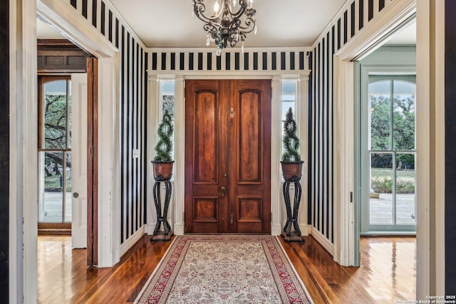 7735 Mocking Bird Ln, San Antonio, TX 78229 - foyer entrance featuring a chandelier, wood finished floors, baseboards, and wallpapered walls