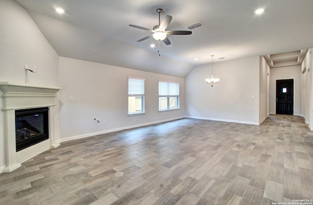 2035 Stephanie Ave, New Braunfels, TX 78132 - unfurnished living room featuring a glass covered fireplace, a ceiling fan, vaulted ceiling, light wood-style floors, and a chandelier