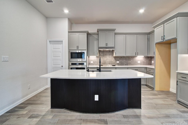 2035 Stephanie Ave, New Braunfels, TX 78132 - kitchen with stainless steel appliances, gray cabinets, decorative backsplash, light wood-type flooring, and recessed lighting