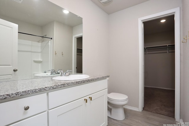10787 Giacconi, Converse, TX 78109 - full bathroom featuring vanity, wood finished floors, toilet, a walk in closet, and a shower