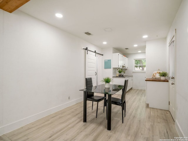 11105 Lone Shadow, Live Oak, TX 78233 - dining room with a barn door, light wood-style floors, recessed lighting, and baseboards