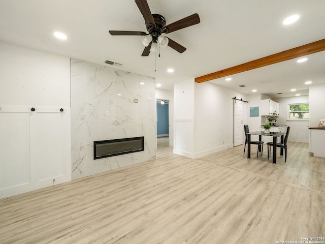 11105 Lone Shadow, Live Oak, TX 78233 - living room featuring a barn door, recessed lighting, a ceiling fan, light wood finished floors, and a premium fireplace