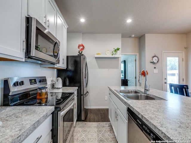 607 Pleasanton Spg, San Antonio, TX 78221 - kitchen with stainless steel appliances, a sink, light wood finished floors, white cabinetry, and recessed lighting