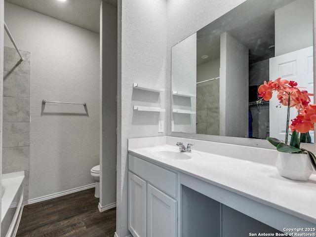 607 Pleasanton Spg, San Antonio, TX 78221 - full bathroom featuring wood finished floors, vanity, toilet, baseboards, and a textured wall