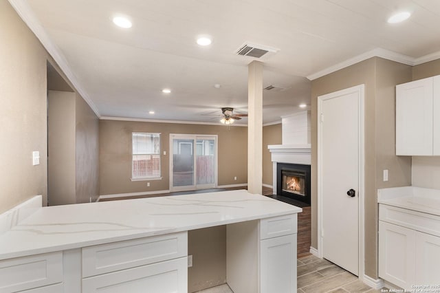 4543 Stradford, San Antonio, TX 78217 - kitchen featuring crown molding, white cabinetry, ceiling fan, light stone counters, and a fireplace