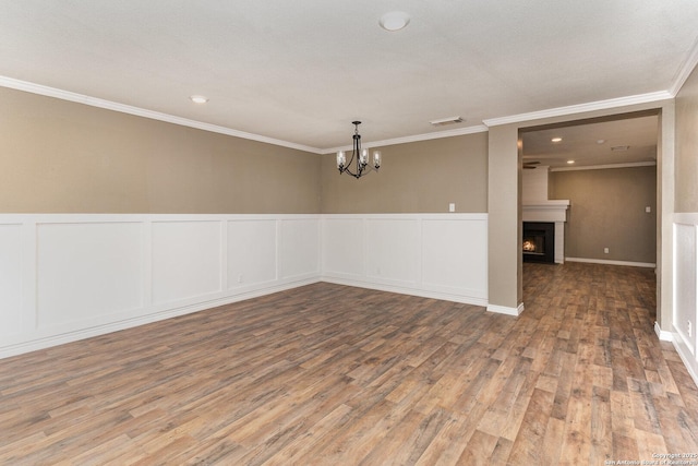 4543 Stradford, San Antonio, TX 78217 - unfurnished room with wood finished floors, a chandelier, wainscoting, a decorative wall, and ornamental molding