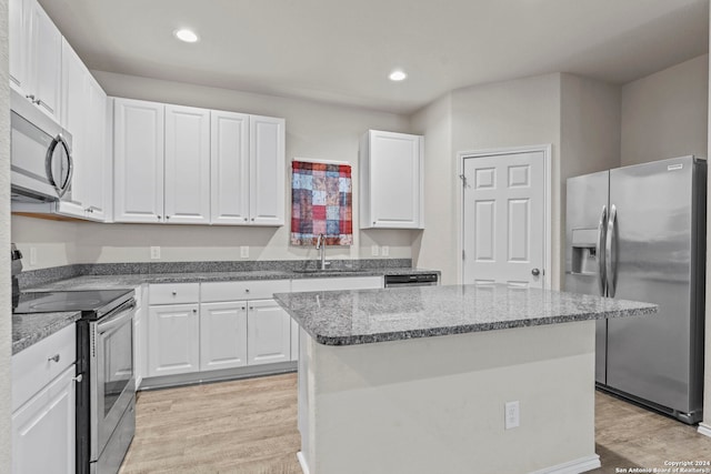 7115 Mesa Clfs, Converse, TX 78109 - kitchen with appliances with stainless steel finishes, a sink, light wood finished floors, white cabinets, and a kitchen island