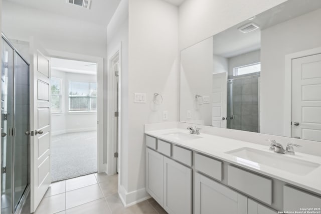 11554 Cottage Pt, San Antonio, TX 78254 - bathroom featuring double vanity, a shower stall, baseboards, and tile patterned floors