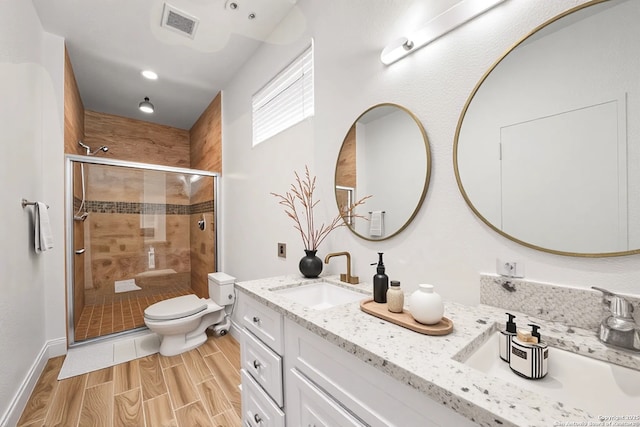 9927 Sandy Fld, San Antonio, TX 78245 - full bath featuring double vanity, toilet, a shower stall, and wood finish floors