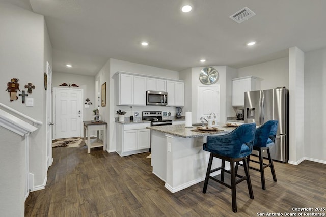 437 Signe, Seguin, TX 78155 - kitchen featuring appliances with stainless steel finishes, white cabinets, dark wood-type flooring, and recessed lighting