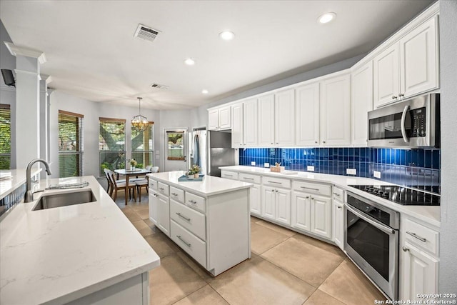 2630 Starlight Ct, San Antonio, TX 78261 - kitchen with appliances with stainless steel finishes, a sink, a kitchen island, a chandelier, and tasteful backsplash