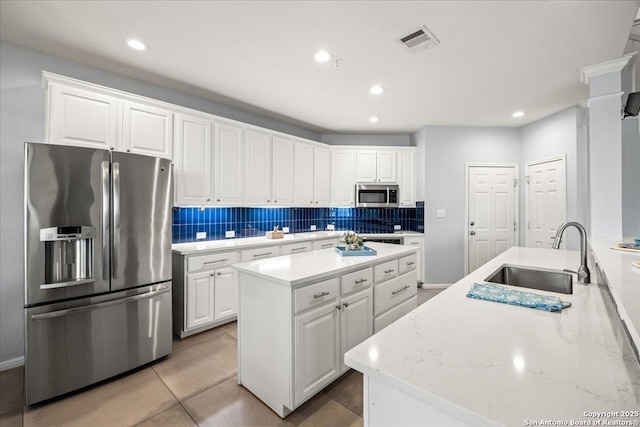 2630 Starlight Ct, San Antonio, TX 78261 - kitchen with appliances with stainless steel finishes, a sink, decorative backsplash, white cabinetry, and recessed lighting