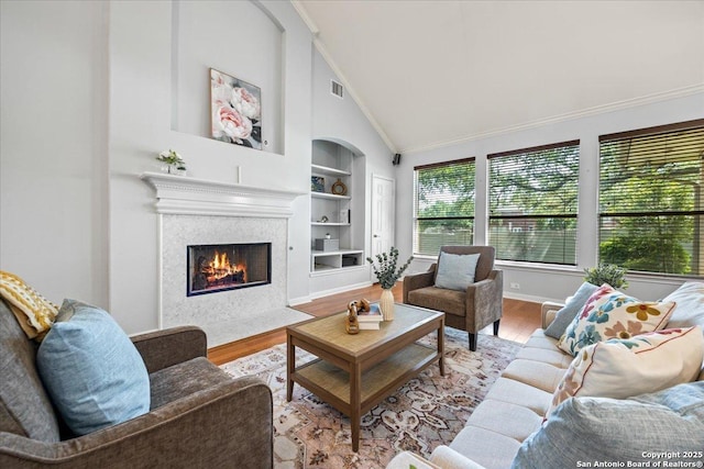 2630 Starlight Ct, San Antonio, TX 78261 - living room with wood finished floors, built in features, a premium fireplace, crown molding, and baseboards