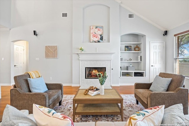 2630 Starlight Ct, San Antonio, TX 78261 - living room with built in shelves, arched walkways, high vaulted ceiling, wood finished floors, and ornamental molding
