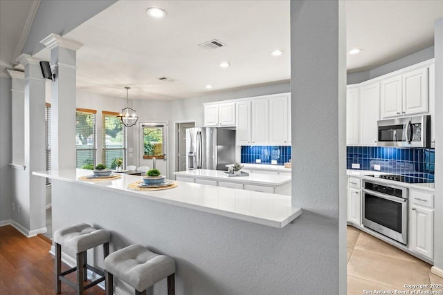 2630 Starlight Ct, San Antonio, TX 78261 - kitchen featuring appliances with stainless steel finishes, a center island, backsplash, a kitchen breakfast bar, and recessed lighting