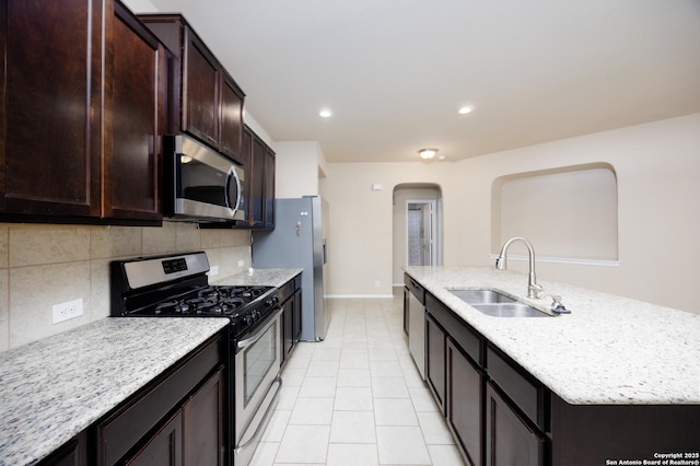 15106 Field Sparrow, San Antonio, TX 78253 - kitchen featuring stainless steel appliances, a sink, arched walkways, a kitchen island with sink, and decorative backsplash