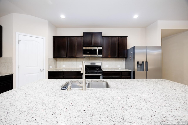 15106 Field Sparrow, San Antonio, TX 78253 - kitchen with stainless steel appliances, a sink, backsplash, dark brown cabinets, and light stone counters