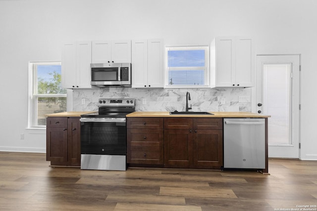 377 County Road 444, Hondo, TX 78861 - kitchen with stainless steel appliances, a sink, butcher block countertops, dark wood-style flooring, and a high ceiling