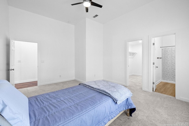 377 County Road 444, Hondo, TX 78861 - carpeted bedroom with a towering ceiling, a walk in closet, baseboards, a ceiling fan, and connected bathroom