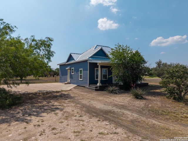 377 County Road 444, Hondo, TX 78861 - view of front of home with covered porch, dirt driveway, and metal roof