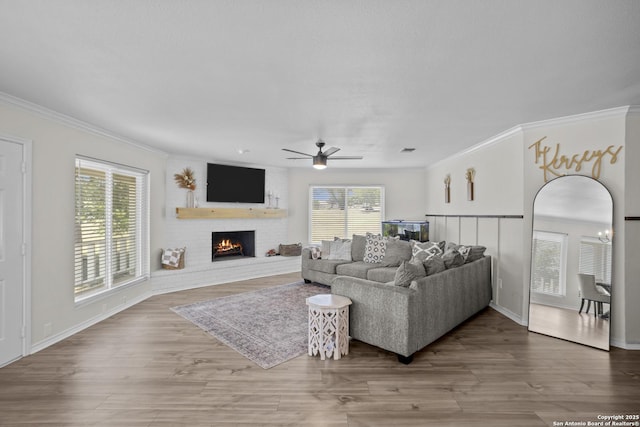 220 Glenvalley, Bandera, TX 78003 - living area with plenty of natural light, ornamental molding, a ceiling fan, a fireplace, and wood finished floors