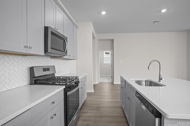 13442 Cosette Xing, San Antonio, TX 78253 - kitchen with stainless steel appliances, a sink, tasteful backsplash, baseboards, and dark wood-style flooring