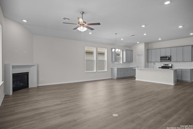 13442 Cosette Xing, San Antonio, TX 78253 - unfurnished living room with ceiling fan, a glass covered fireplace, recessed lighting, a sink, and wood finished floors