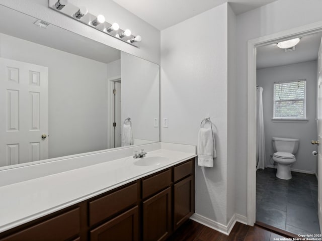 627 Midway, San Antonio, TX 78258 - bathroom featuring vanity, toilet, wood finished floors, and baseboards