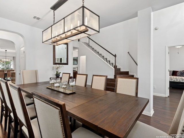 627 Midway, San Antonio, TX 78258 - dining space featuring arched walkways, wood finished floors, stairs, baseboards, and a chandelier