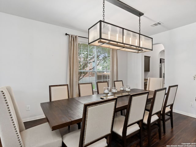 627 Midway, San Antonio, TX 78258 - dining room featuring arched walkways, dark wood finished floors, and baseboards