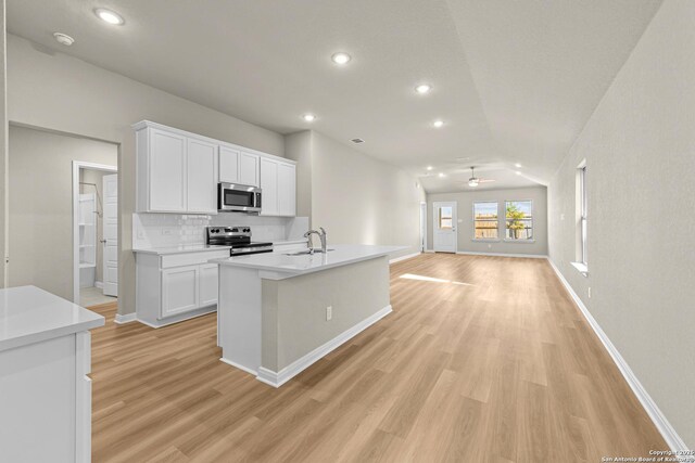 4242 Winston Way, New Braunfels, TX 78130 - kitchen featuring appliances with stainless steel finishes, light wood-style floors, ceiling fan, backsplash, and baseboards