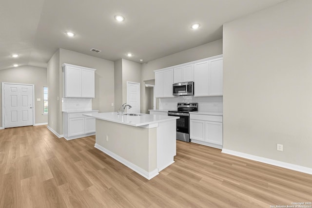 4242 Winston Way, New Braunfels, TX 78130 - kitchen with appliances with stainless steel finishes, backsplash, light wood finished floors, recessed lighting, and a kitchen island with sink