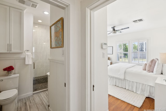 418 Eleanor, San Antonio, TX 78209 - ensuite bathroom with wood finished floors, a ceiling fan, toilet, tiled shower, and recessed lighting