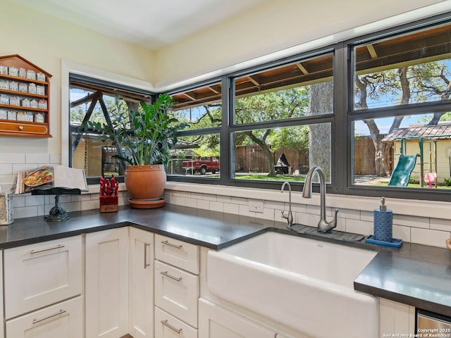 134 Camellia Way, San Antonio, TX 78209 - kitchen featuring a sink, decorative backsplash, white cabinets, dark countertops, and open shelves