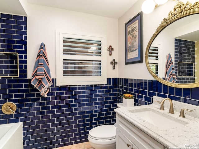 134 Camellia Way, San Antonio, TX 78209 - full bathroom with tile walls, toilet, vanity, a wainscoted wall, and a tub