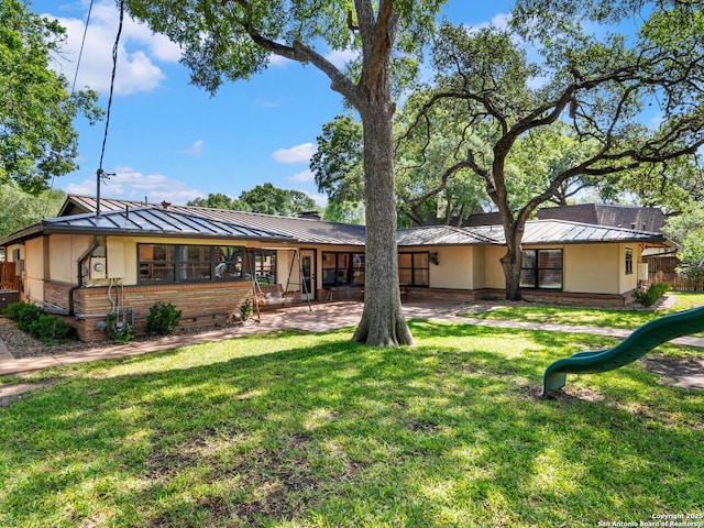 134 Camellia Way, San Antonio, TX 78209 - view of front facade with a standing seam roof, stucco siding, metal roof, and a front yard