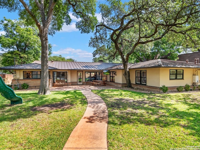 134 Camellia Way, San Antonio, TX 78209 - back of house with stucco siding, a standing seam roof, and a playground