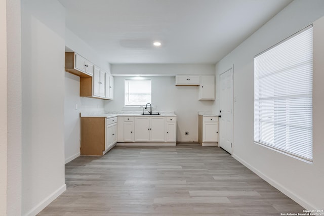 7126 Westbriar, San Antonio, TX 78227 - kitchen featuring a sink, light wood-style flooring, white cabinetry, baseboards, and light countertops