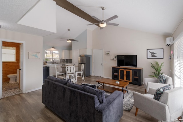 577 Dusty Saddle, Canyon Lake, TX 78133 - living area featuring a ceiling fan, wood finished floors, a wall mounted AC, high vaulted ceiling, and baseboards