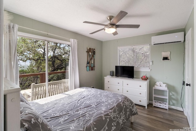 577 Dusty Saddle, Canyon Lake, TX 78133 - bedroom featuring a wall mounted AC, multiple windows, dark wood-type flooring, a textured ceiling, and access to exterior