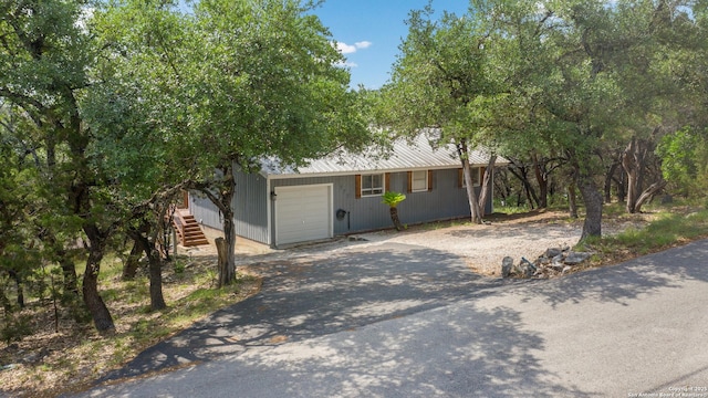 577 Dusty Saddle, Canyon Lake, TX 78133 - ranch-style house featuring an attached garage, metal roof, driveway, and stairs
