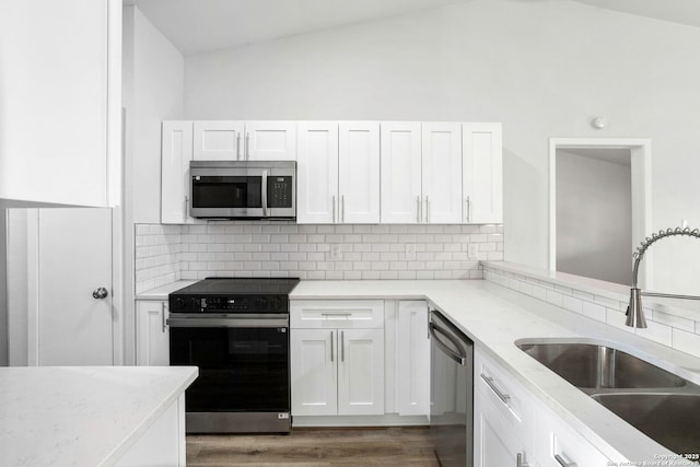 11403 Big Elk, San Antonio, TX 78245 - kitchen featuring stainless steel appliances, a sink, white cabinets, decorative backsplash, and lofted ceiling