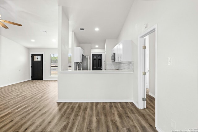 11403 Big Elk, San Antonio, TX 78245 - kitchen featuring wood finished floors, ceiling fan, white cabinets, stainless steel microwave, and decorative backsplash