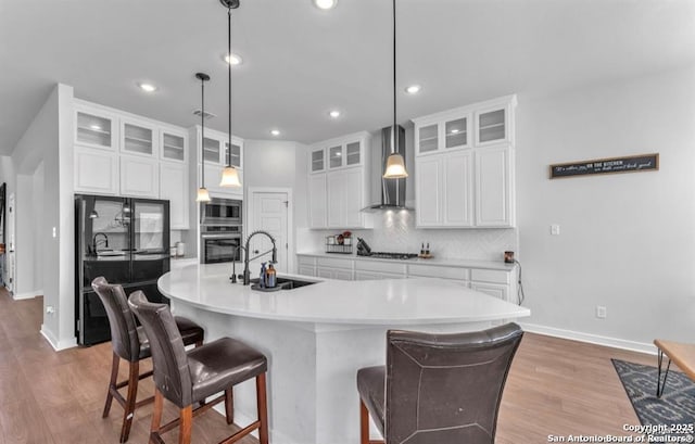 2818 Tortuga Verde, San Antonio, TX 78245 - kitchen featuring a sink, wall chimney exhaust hood, black appliances, tasteful backsplash, and recessed lighting