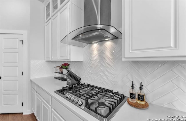 2818 Tortuga Verde, San Antonio, TX 78245 - kitchen with wall chimney range hood, stainless steel gas stovetop, white cabinetry, light countertops, and glass insert cabinets