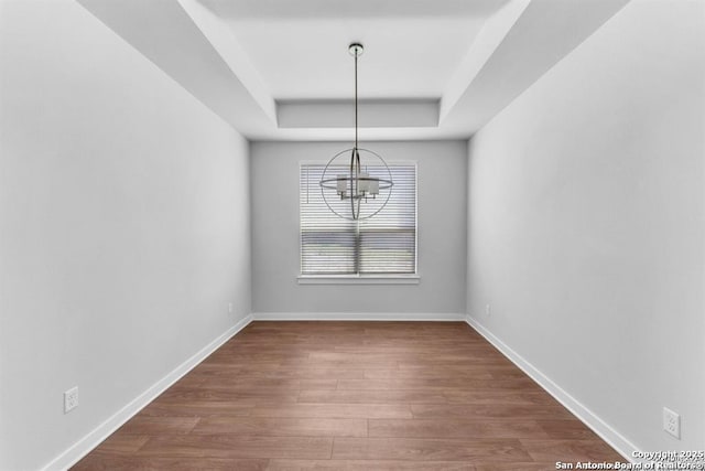 2818 Tortuga Verde, San Antonio, TX 78245 - spare room with a tray ceiling, a chandelier, wood finished floors, and baseboards